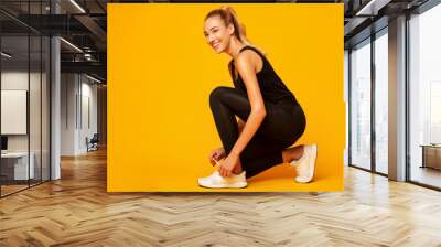 Girl Lacing Shoes Getting Ready For Workout, Yellow Background Wall mural