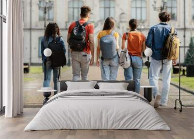 Group of five students with backpacks walking at university campus together Wall mural