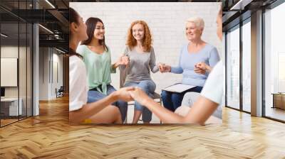 Group Therapy. Smiling Diverse Women Sitting In Circle Holding Hands Indoor. Selective Focus Wall mural