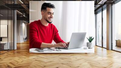 Handsome Arab Male Freelancer Working On Laptop At Home Office Wall mural