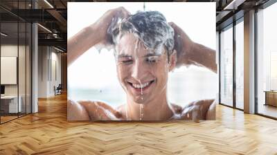 Handsome young male model washing hair with shampoo Wall mural