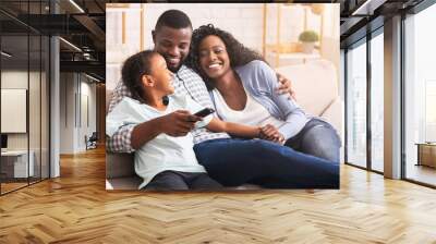 Happy african american family relaxing and watching TV at home Wall mural