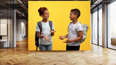 Happy african american schoolers having conversation on yellow Wall mural