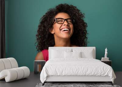 Happy african-american woman laughing over blue background Wall mural