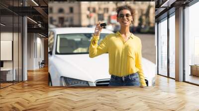 Happy African Girl Showing Automobile Key Standing Near Auto Outdoors Wall mural