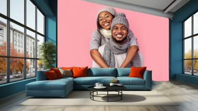 Happy african woman hugging her man from behind, winter set Wall mural