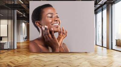 Happy afro woman touching soft smooth skin on her face Wall mural