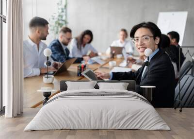 Happy Asian Businessman Using Tablet Sitting With Colleagues In Office Wall mural