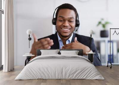 Happy black businessman with headset having online conference Wall mural