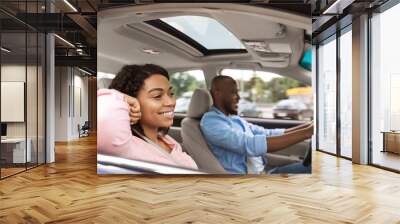 Happy black couple enjoying drive on new car Wall mural