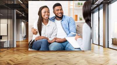 Happy black couple sitting in counselor's office after successful marital therapy, copy space Wall mural