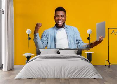 Happy black guy rejoicing success with laptop Wall mural