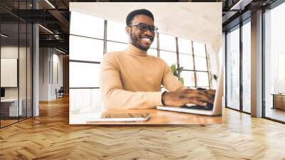 Happy black guy updating his personal online blog Wall mural