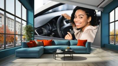 Happy Black Lady Doing Test Drive Posing Sitting In Automobile Wall mural