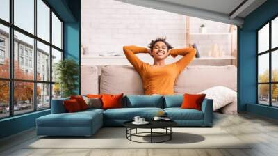 Happy Black Woman Relaxing Sitting On Sofa At Home Wall mural