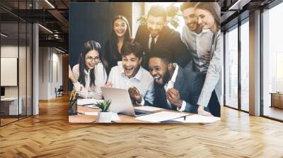 Happy business people celebrating success looking at laptop Wall mural