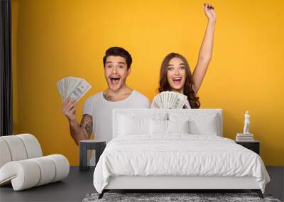 Happy couple holding bunch of money banknotes Wall mural