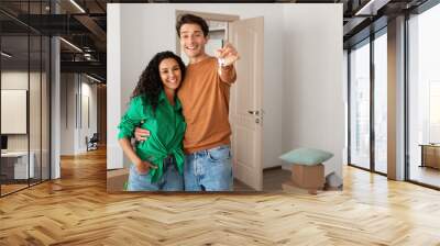 Happy couple showing keys from flat on moving day Wall mural