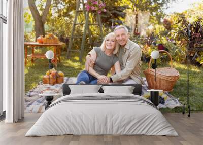 Happy elderly couple resting in autumn park, having picnic and smiling to camera, copy space Wall mural