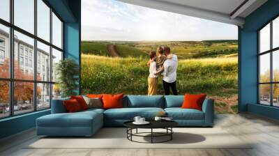 Happy family enjoying beautiful landscape outdoors in the field Wall mural