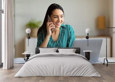 Happy Female Entrepreneur Talking On Cellphone In Modern Office Wall mural