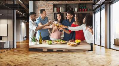 Happy friends drinking and eating together in kitchen Wall mural