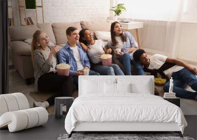 Happy friends watching comedy film and eating popcorn Wall mural