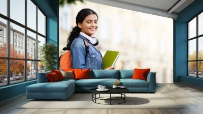 Happy Indian student with working books outside Wall mural