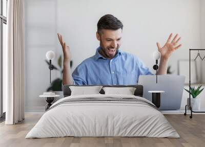 Happy male entrepreneur emotionally celebrating business success with laptop in office Wall mural