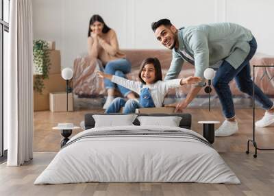 Happy middle eastern family celebrating moving day in new apartment Wall mural