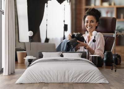 Happy millennial lady photographer working at office Wall mural