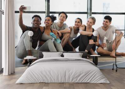 Happy multicultural friends taking selfie on smartphone after fitness training Wall mural