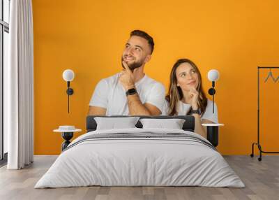 Happy pensive young european guy and woman think, look at free space Wall mural