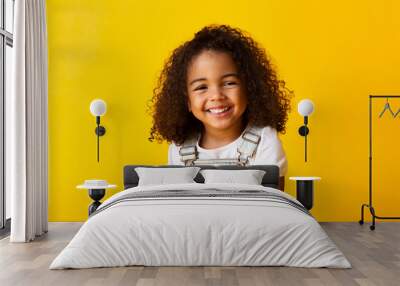 Happy smiling african-american child girl, yellow background Wall mural