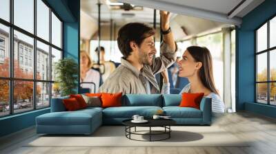 Happy smiling couple standing in bus and talking Wall mural