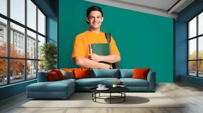 Happy student with books and backpack over turquoise background, copy space Wall mural