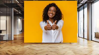 Happy young black woman showing thumbs up Wall mural