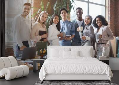 Happy young business team posing in office during working day Wall mural