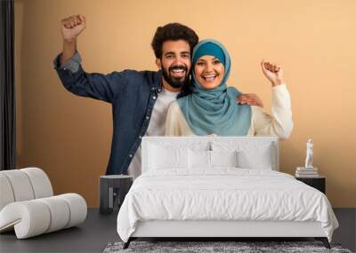 Happy Young Muslim Couple Holding Piggy Bank And Celebrating Success Wall mural