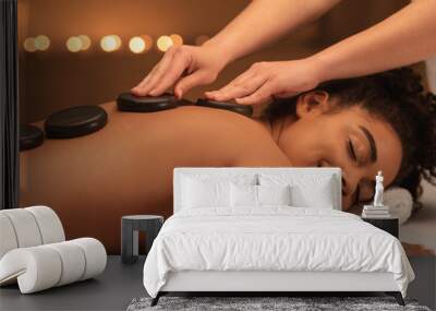 Healing hot stone massage for joyful black woman Wall mural