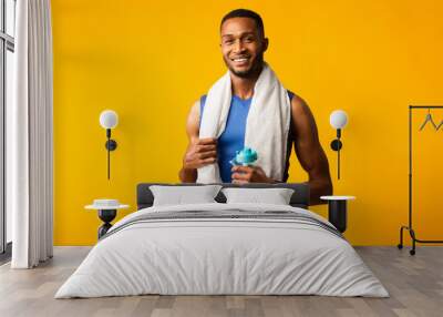 Healthy afro guy holding bottle of water Wall mural