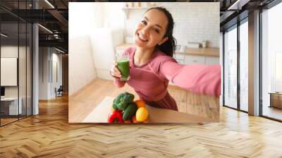 Healthy lady making selfie with green smoothie after workout indoor Wall mural