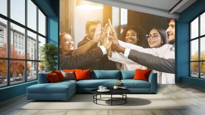 High-five for success. Diverse group of business colleagues in office Wall mural