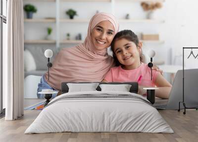 Home Portrait Of Happy Muslim Woman In Hijab And Her Little Daughter Wall mural