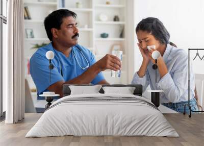 Indian doctor man comforting upset female patient crying during appointment in clinic Wall mural