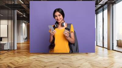 Indian female student holding mobile phone and coffee Wall mural