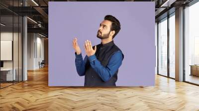 Indian man praying to God, asking for help or forgiveness on lilac background Wall mural