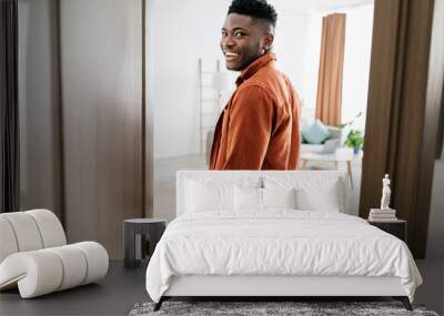 Joyful African American Male Entering His New Apartment Opening Door Wall mural