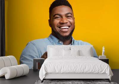 Joyful black guy pointing fingers at camera on yellow background Wall mural