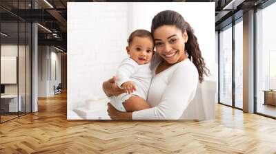 Joyful Black Mom Holding And Hugging Adorable Baby In Bedroom Wall mural